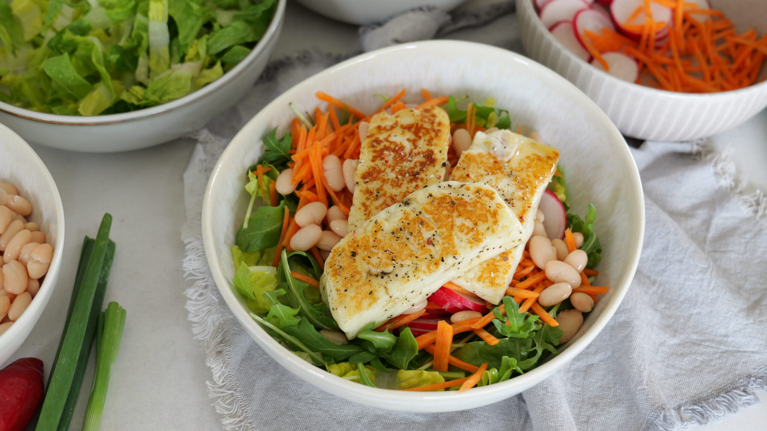Salatbowl mit Rucola, weißen Bohnen und Honig-glasiertem Halloumi